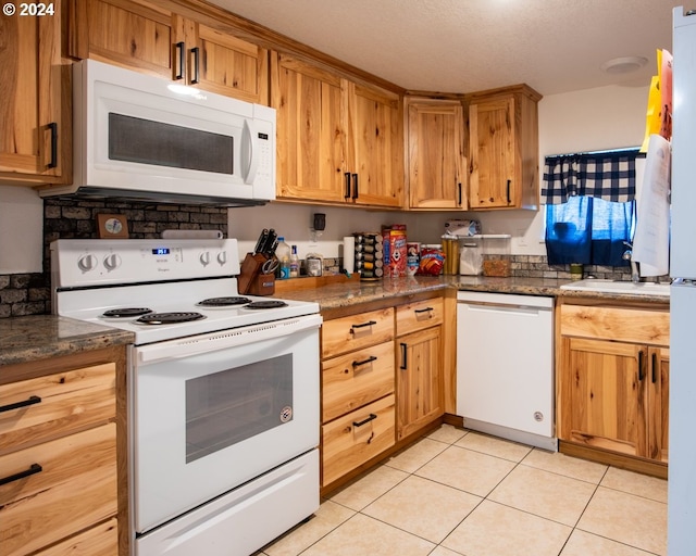 kitchen featuring white appliances and light tile flooring