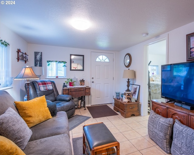 tiled living room featuring a textured ceiling