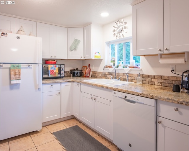 kitchen featuring light stone counters, sink, white cabinetry, and white appliances