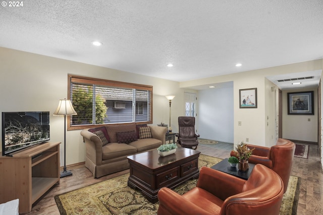 living room featuring light hardwood / wood-style flooring and a textured ceiling