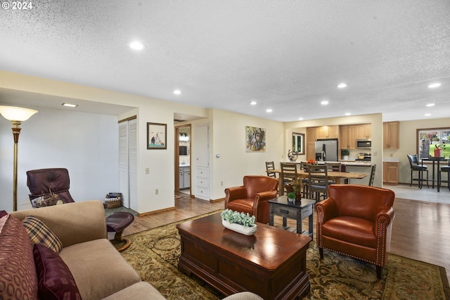 living room featuring a textured ceiling and hardwood / wood-style flooring