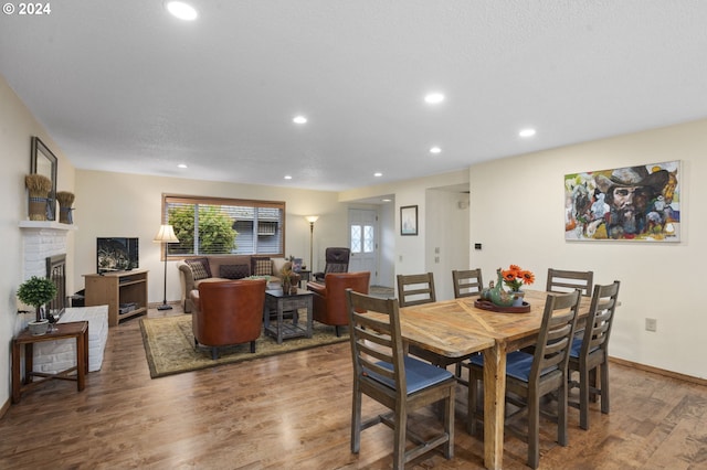 dining room featuring hardwood / wood-style flooring and a fireplace