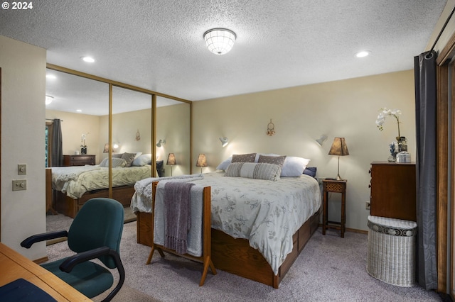 bedroom with a textured ceiling, light colored carpet, and a closet