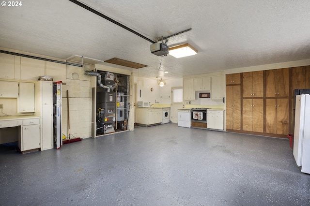 garage with washer and dryer, a garage door opener, white fridge, and heating unit