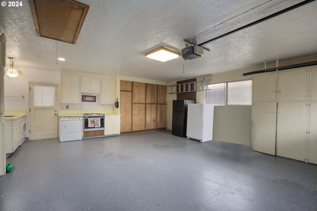 15775 SW Queen Victoria Pl, King City, OR 97224 - garage featuring washer / dryer, a garage door opener, and freestanding refrigerator