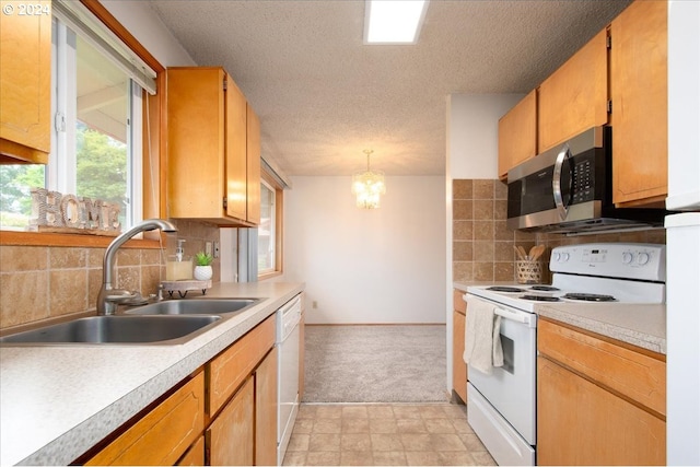 kitchen featuring decorative backsplash, a notable chandelier, light tile patterned floors, white appliances, and sink