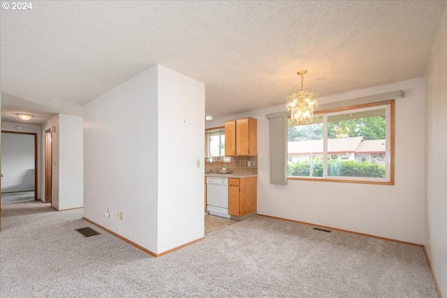 unfurnished living room with a textured ceiling, an inviting chandelier, and light carpet