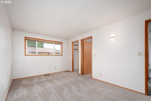 carpeted spare room with a textured ceiling