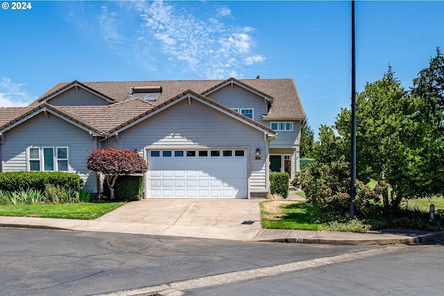 view of front of home featuring a garage, a front yard, driveway, and a tiled roof