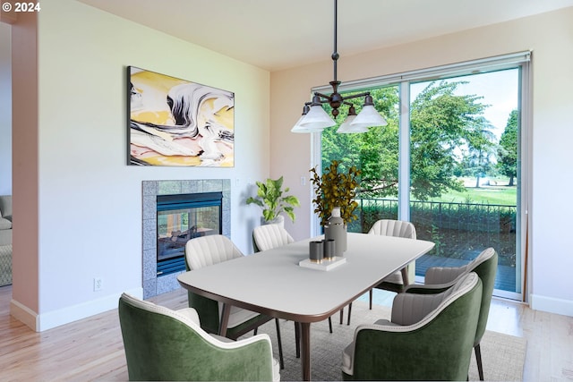 dining room with light wood-style flooring and an inviting chandelier