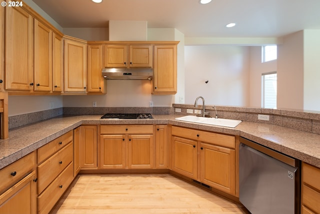 kitchen with stainless steel appliances, under cabinet range hood, a sink, and tile countertops