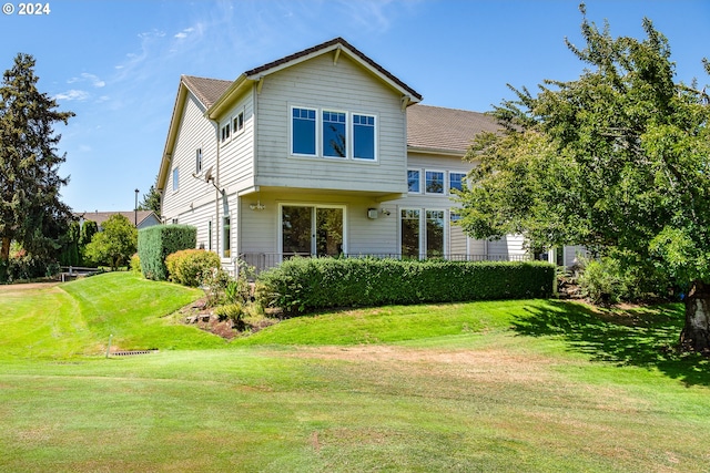 rear view of house with a lawn and a garage