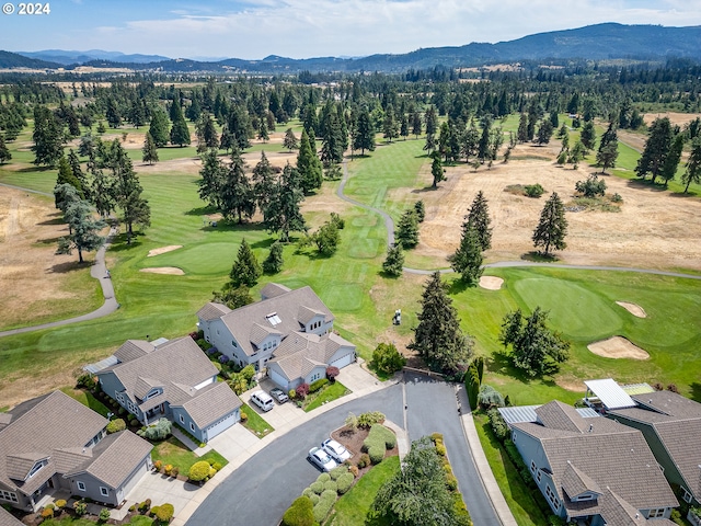 drone / aerial view featuring view of golf course, a mountain view, and a residential view