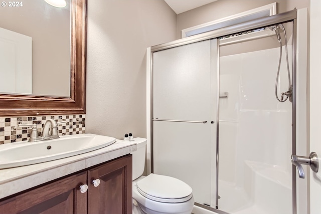 full bath featuring tasteful backsplash, a stall shower, vanity, and toilet