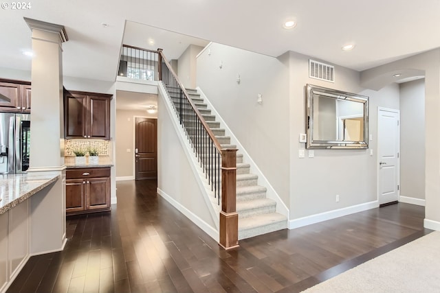 staircase with hardwood / wood-style floors and decorative columns