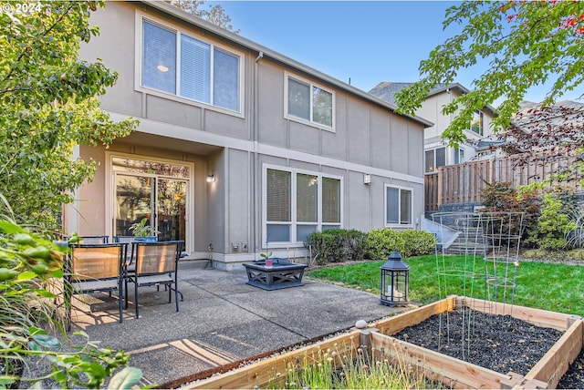 rear view of property featuring fence, outdoor dining area, a yard, a patio area, and stucco siding