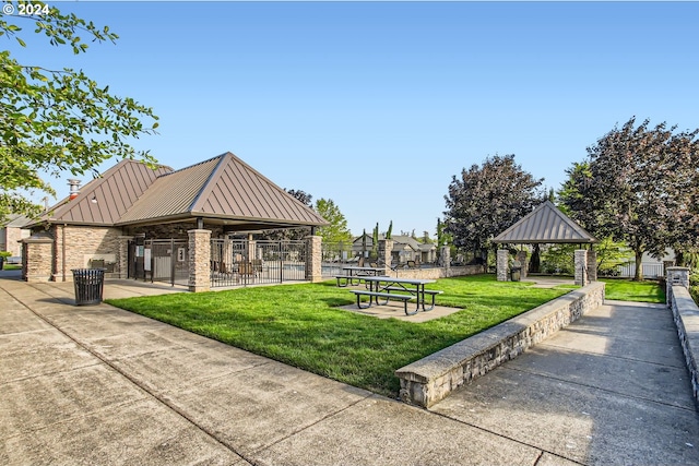 view of community with a yard, fence, and a gazebo