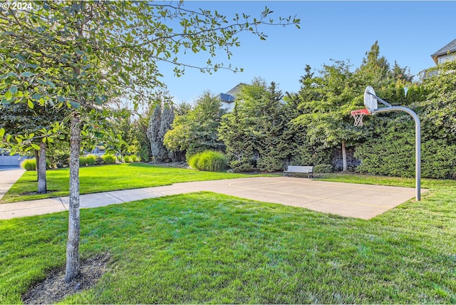 view of basketball court with community basketball court and a lawn