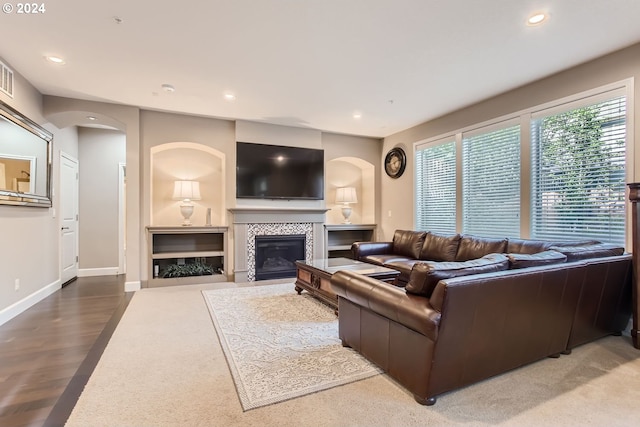 living area with a fireplace, baseboards, arched walkways, and recessed lighting