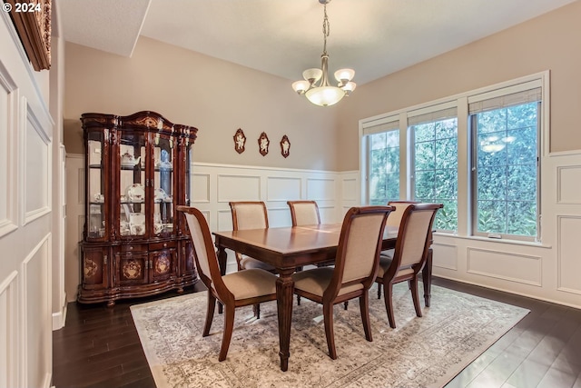 dining room featuring dark wood-type flooring and an inviting chandelier