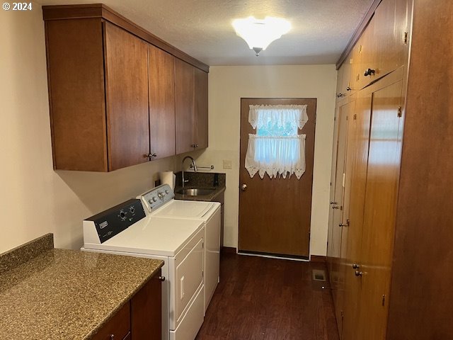 washroom featuring cabinets, sink, independent washer and dryer, and dark hardwood / wood-style floors