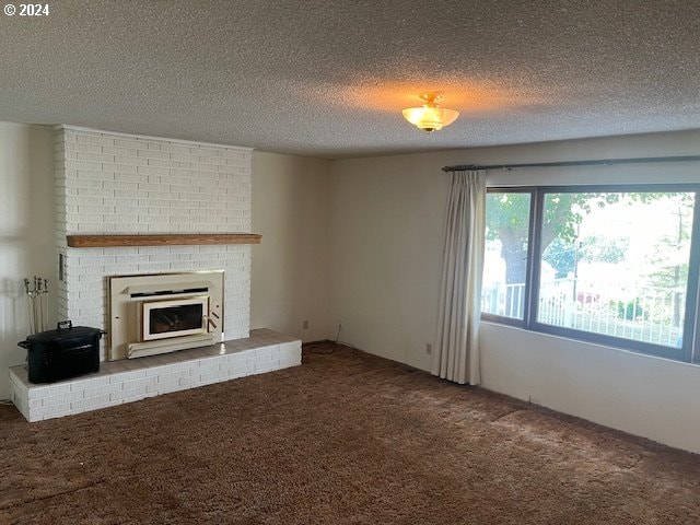 unfurnished living room with a fireplace, carpet, and a textured ceiling