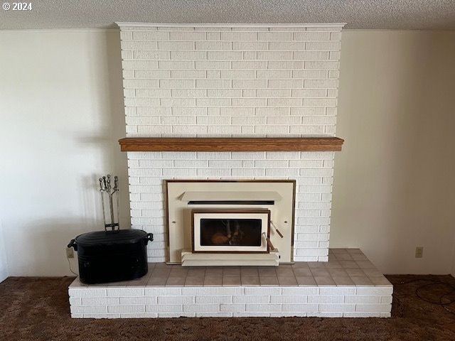 details featuring a brick fireplace, a textured ceiling, and carpet flooring