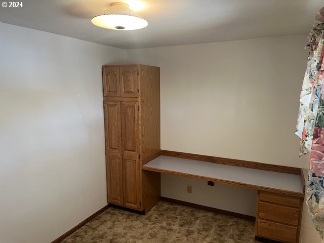 interior space with light colored carpet and built in desk