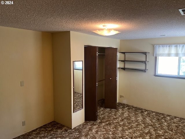 unfurnished bedroom featuring a closet, a textured ceiling, and carpet flooring