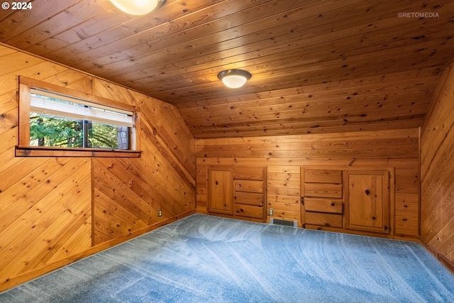 additional living space with carpet floors, wood ceiling, and wooden walls