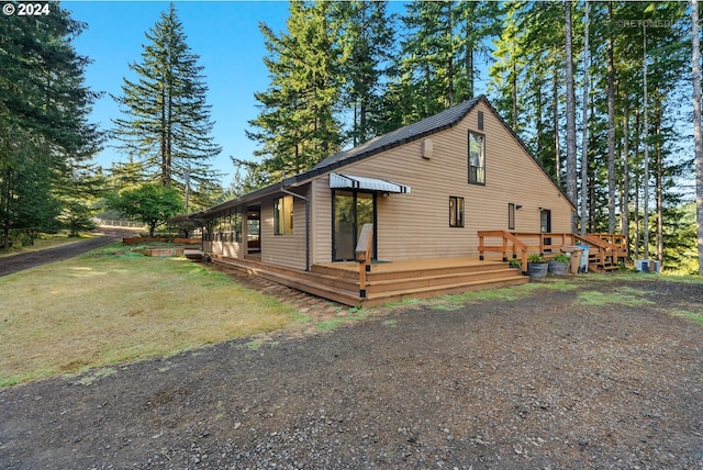 view of property exterior with a wooden deck and a yard