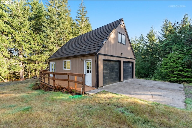 view of property exterior with a lawn, an outbuilding, and a garage