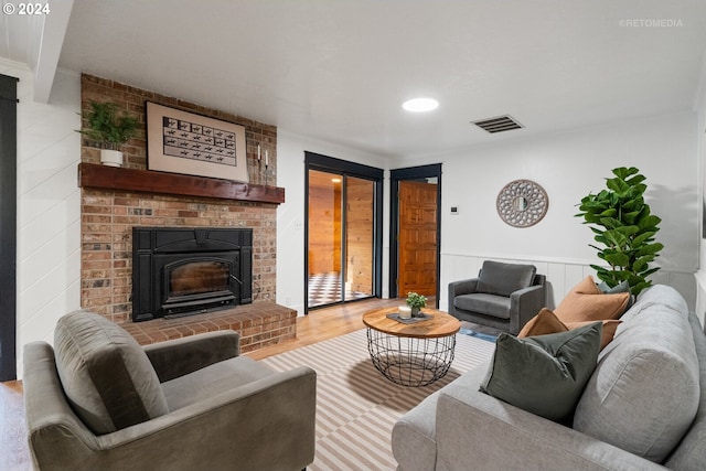 living room with hardwood / wood-style floors and a brick fireplace