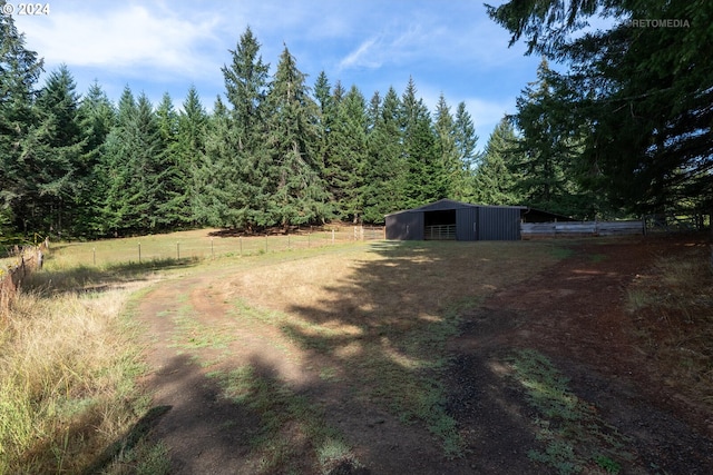 view of yard featuring an outdoor structure and a rural view