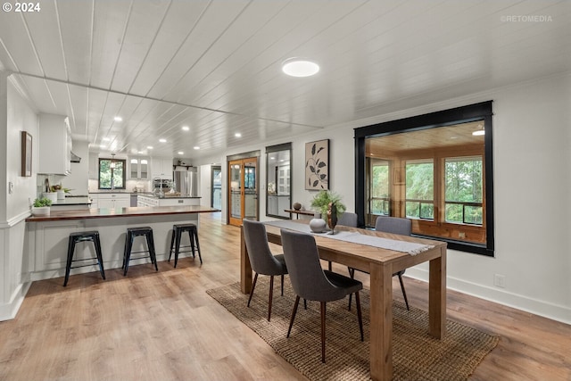 dining space with wood ceiling, light hardwood / wood-style flooring, and a wealth of natural light