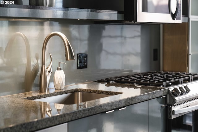 details featuring dark stone countertops and appliances with stainless steel finishes