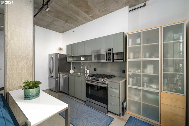 kitchen with stainless steel appliances, gray cabinetry, and sink