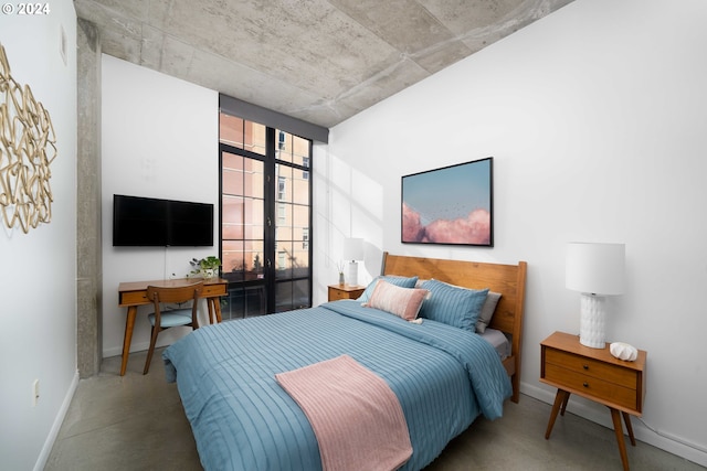 bedroom featuring french doors and concrete flooring