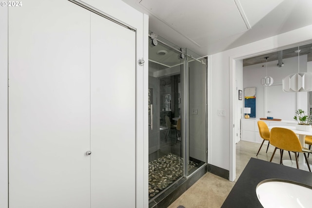 bathroom with vanity, concrete floors, and a shower with shower door