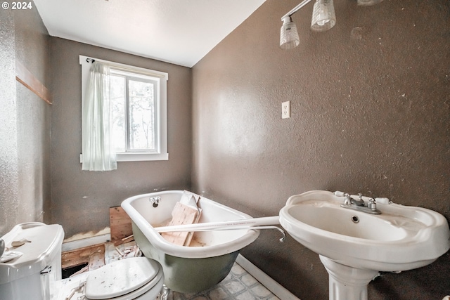 bathroom featuring a bathing tub, toilet, and lofted ceiling