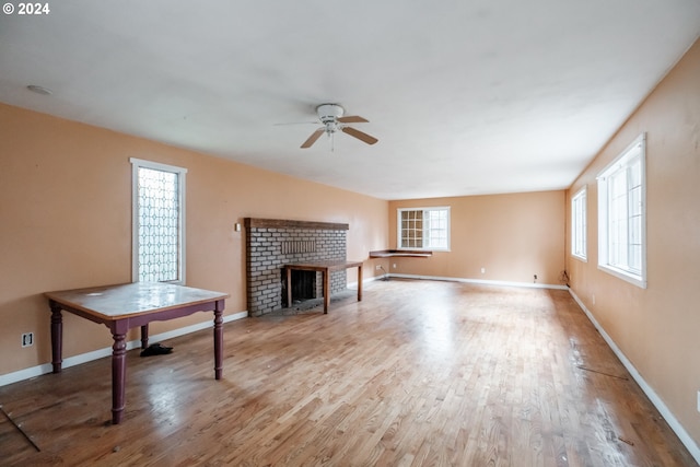 unfurnished living room featuring a fireplace, hardwood / wood-style floors, a wealth of natural light, and ceiling fan