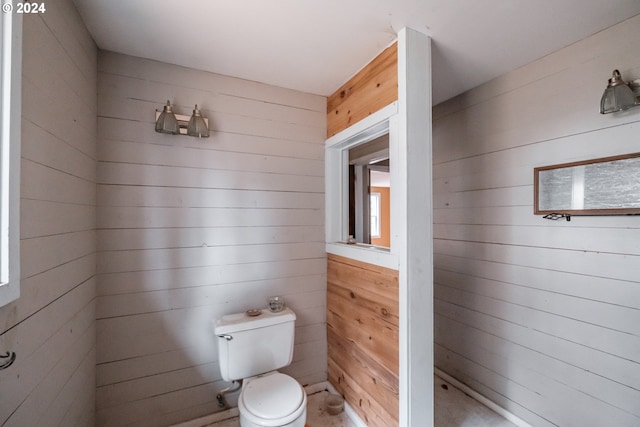 bathroom with wood walls and toilet