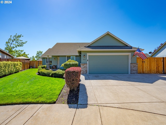 single story home featuring driveway, brick siding, a front lawn, and fence