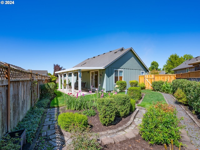 back of house featuring board and batten siding, a patio area, and a fenced backyard