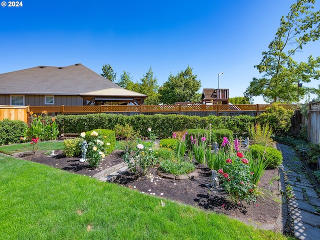 view of yard featuring a gazebo, a fenced backyard, and a vegetable garden