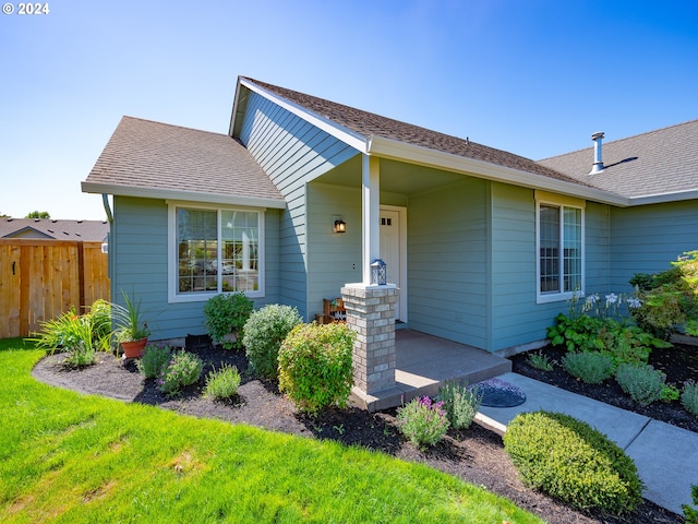 view of front of house with roof with shingles and fence