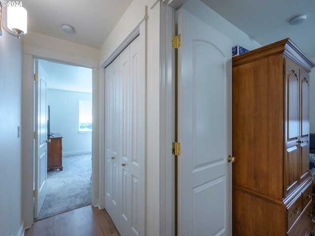 corridor featuring baseboards and wood finished floors