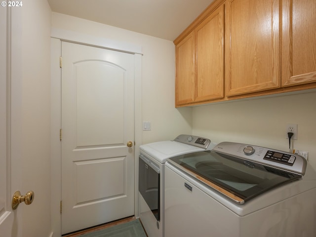 laundry room with cabinet space and washing machine and clothes dryer