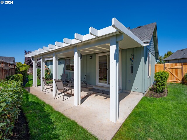 back of house featuring a lawn and a patio