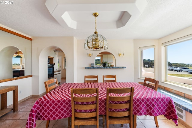 dining area with a textured ceiling, light tile patterned flooring, and a notable chandelier